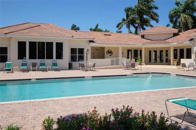 view of swimming pool featuring a patio and french doors