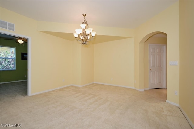 carpeted spare room with a chandelier