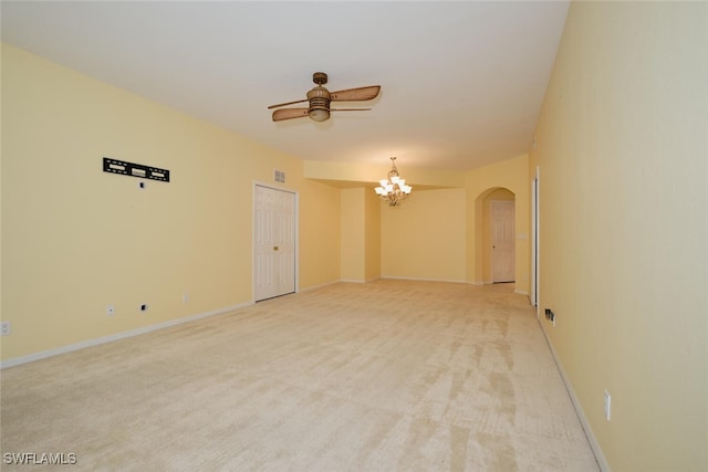 unfurnished room with ceiling fan with notable chandelier and light colored carpet