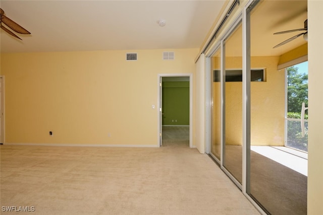 empty room featuring ceiling fan and light colored carpet