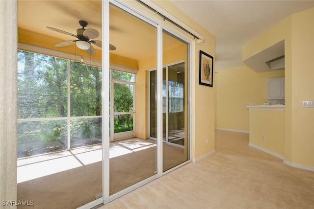 doorway to outside with light carpet and ceiling fan