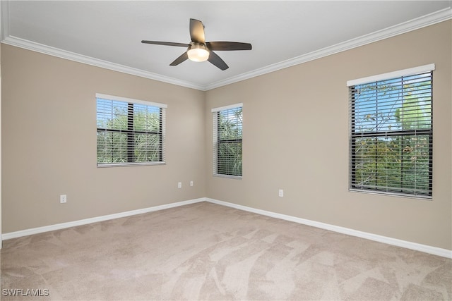 unfurnished room with light colored carpet, ceiling fan, baseboards, and ornamental molding