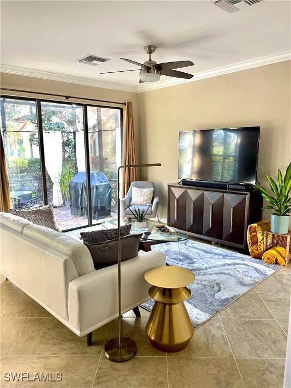 tiled living room featuring crown molding, visible vents, and ceiling fan