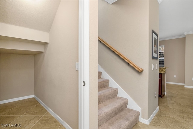 stairs with baseboards, crown molding, and tile patterned flooring