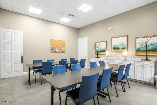 dining space featuring light tile patterned floors, a paneled ceiling, and visible vents