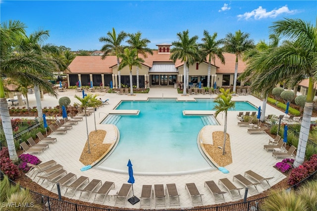 pool with a patio area and fence