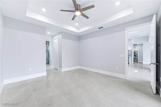 unfurnished room featuring a tray ceiling and ceiling fan