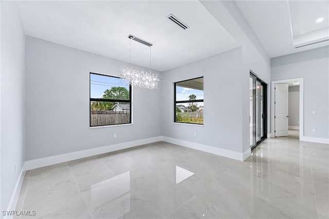 unfurnished room with a notable chandelier