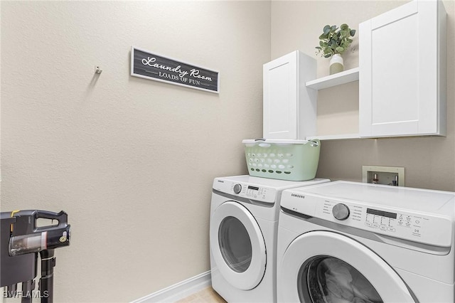 laundry area with washer and dryer and cabinets