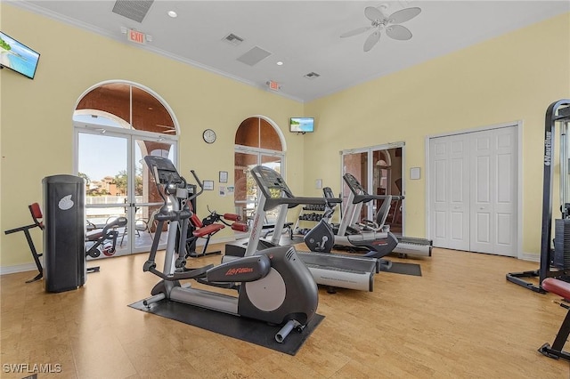 workout area with ceiling fan, light wood-type flooring, and crown molding