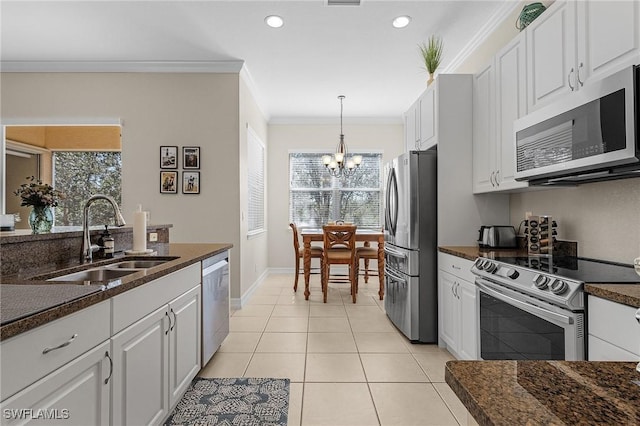 kitchen with sink, white cabinets, ornamental molding, a chandelier, and appliances with stainless steel finishes