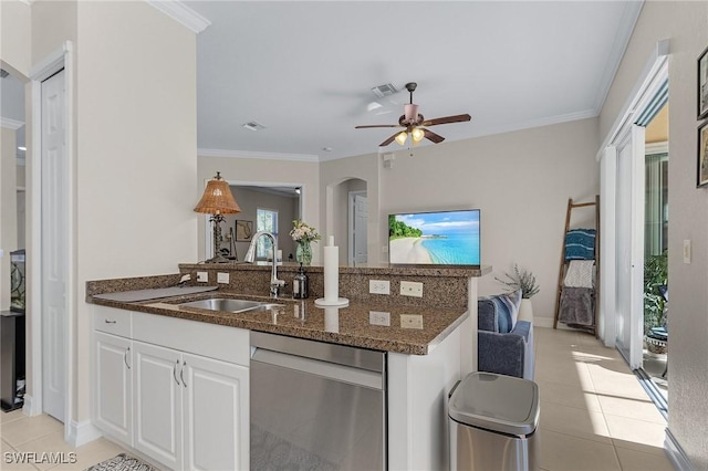 kitchen featuring dark stone countertops, light tile patterned floors, white cabinets, stainless steel dishwasher, and sink