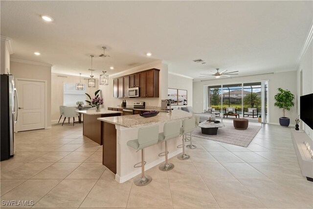 kitchen featuring light tile patterned floors, ornamental molding, appliances with stainless steel finishes, decorative light fixtures, and kitchen peninsula