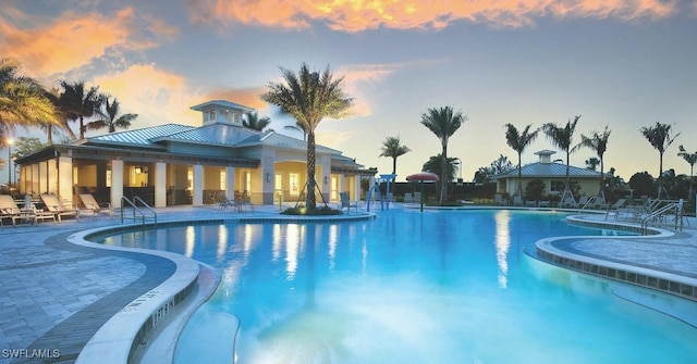 pool at dusk featuring a patio area