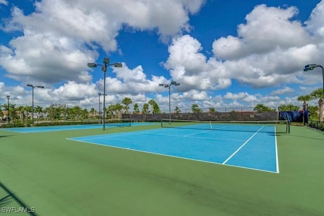 view of tennis court featuring basketball hoop