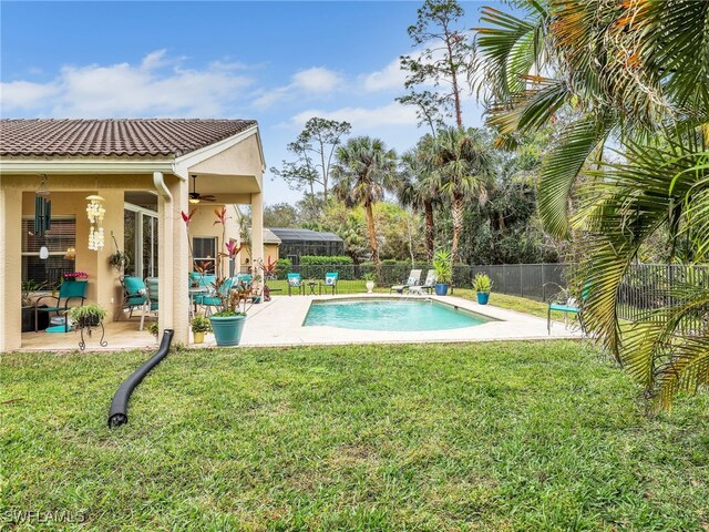 view of swimming pool featuring fence, a yard, a fenced in pool, and ceiling fan
