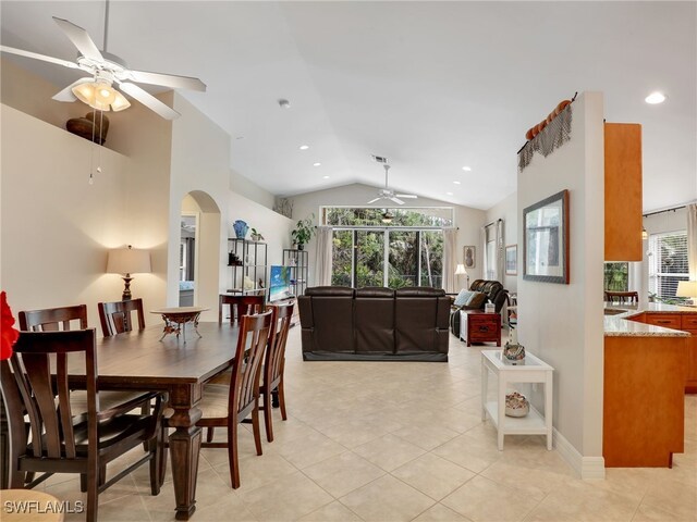 dining area with arched walkways, ceiling fan, lofted ceiling, and a healthy amount of sunlight