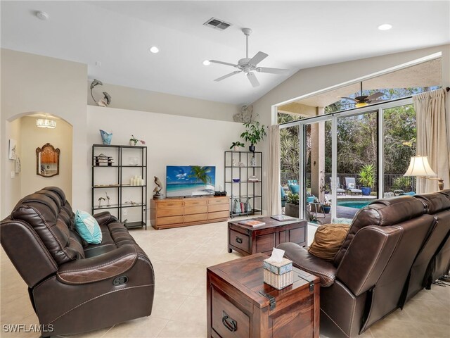living area with vaulted ceiling, light tile patterned flooring, ceiling fan, arched walkways, and visible vents