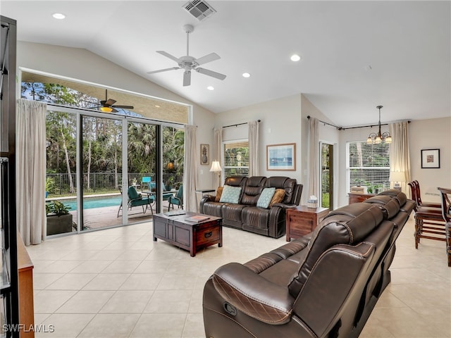 tiled living room featuring vaulted ceiling, ceiling fan with notable chandelier, and a wealth of natural light