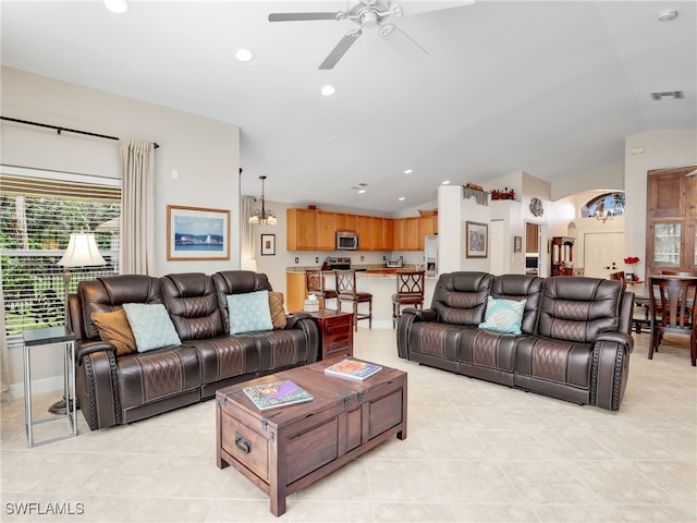 tiled living room with lofted ceiling and ceiling fan with notable chandelier