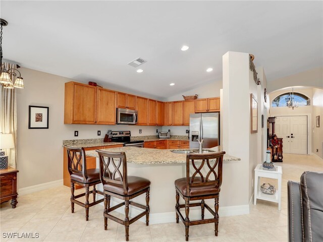 kitchen featuring a sink, arched walkways, a peninsula, appliances with stainless steel finishes, and visible vents