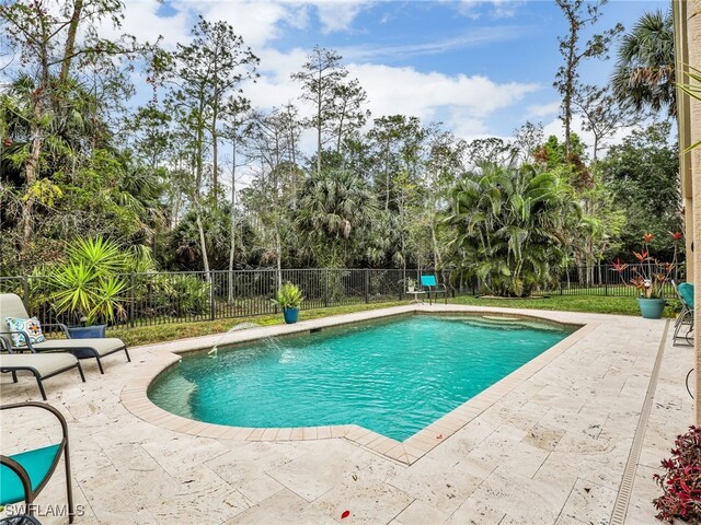 view of swimming pool featuring fence, a fenced in pool, and a patio