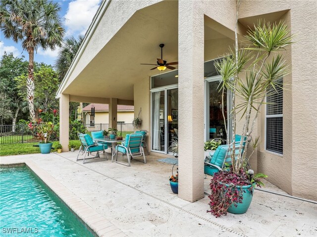 view of patio with fence, a ceiling fan, and a fenced in pool