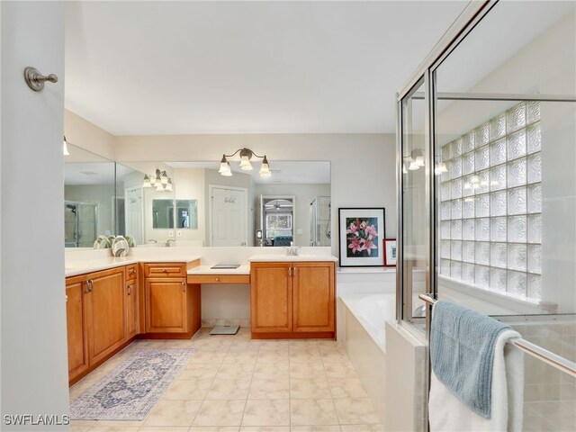 full bathroom featuring a sink, double vanity, a stall shower, a notable chandelier, and a garden tub