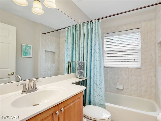 bathroom featuring toilet, vanity, and shower / bath combo with shower curtain