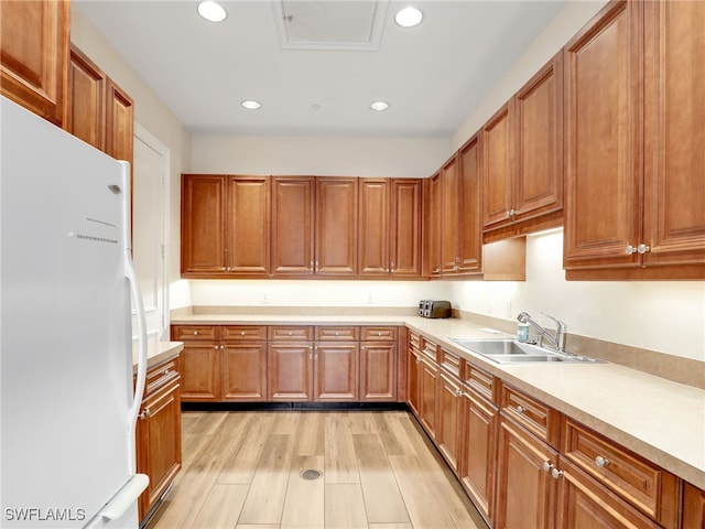 kitchen featuring sink, light hardwood / wood-style flooring, and white fridge