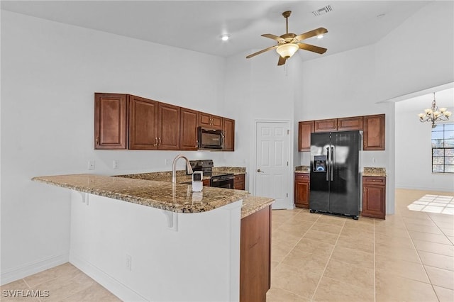 kitchen with kitchen peninsula, a breakfast bar area, high vaulted ceiling, ceiling fan with notable chandelier, and black appliances