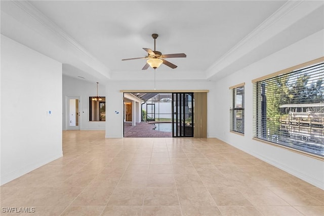 empty room featuring light tile patterned floors, ceiling fan with notable chandelier, and a tray ceiling