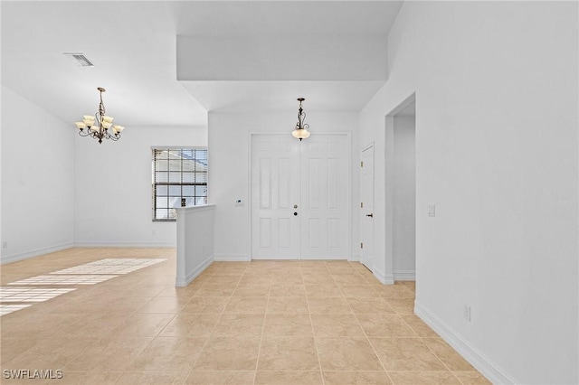 tiled foyer with a chandelier