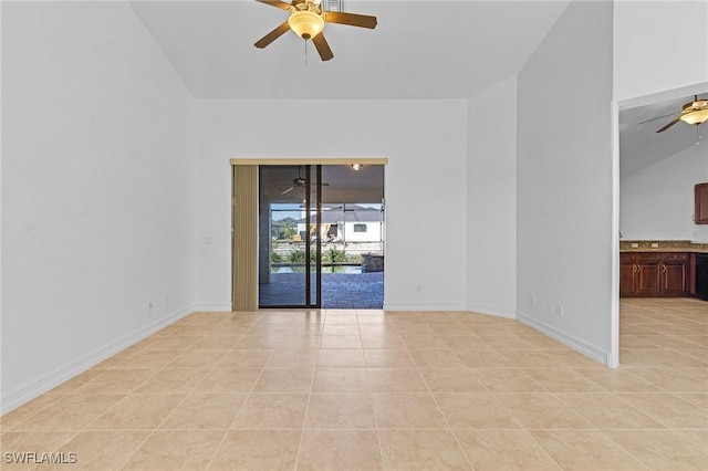 spare room featuring ceiling fan, light tile patterned floors, and lofted ceiling