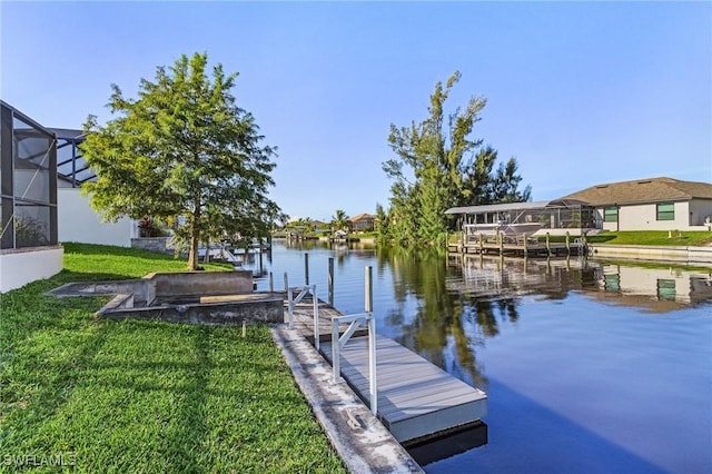 view of dock with glass enclosure, a yard, and a water view