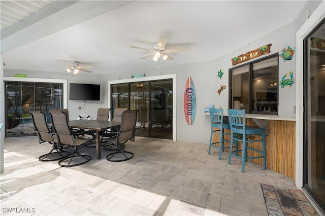 view of patio with ceiling fan and a bar