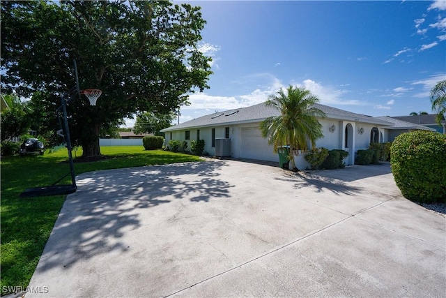 ranch-style home featuring central air condition unit, a front yard, and a garage