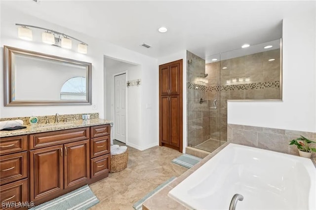 bathroom featuring vanity and independent shower and bath