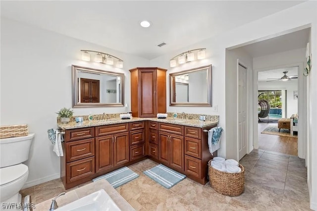 bathroom featuring ceiling fan, toilet, and vanity