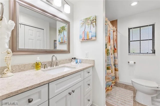 bathroom with tile patterned flooring, vanity, and toilet