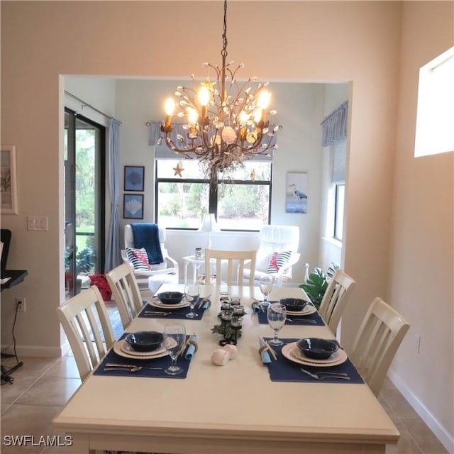 tiled dining room featuring an inviting chandelier