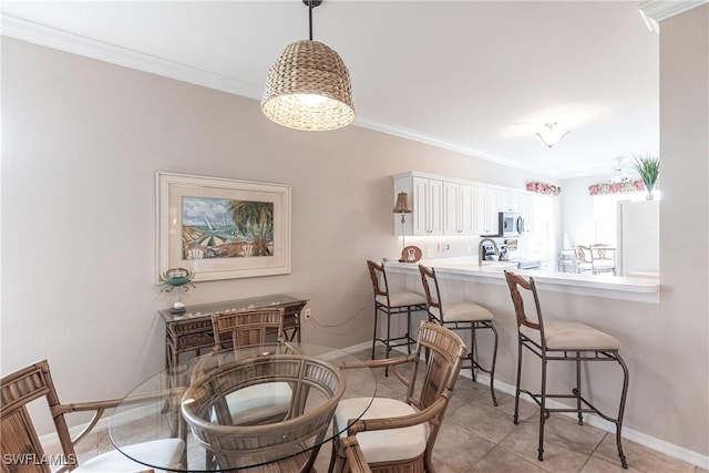 tiled dining room featuring ornamental molding