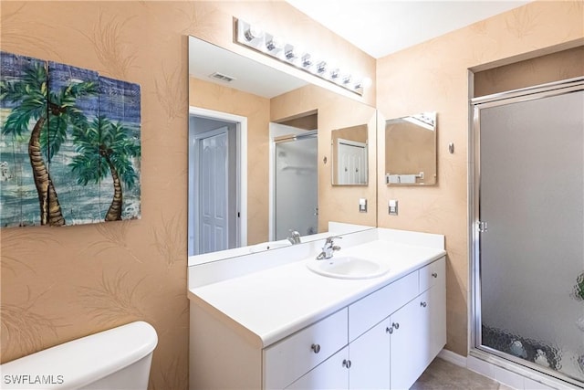 bathroom featuring toilet, an enclosed shower, and vanity