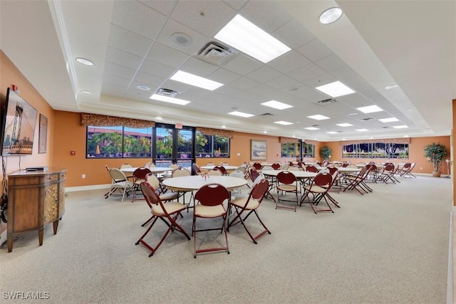 carpeted dining room featuring a paneled ceiling