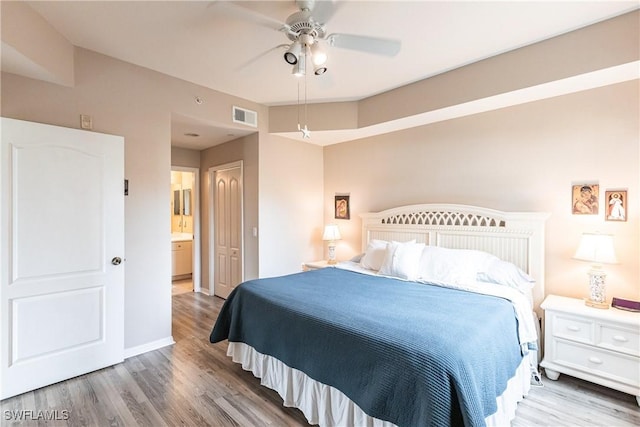 bedroom with ceiling fan, ensuite bathroom, and wood-type flooring