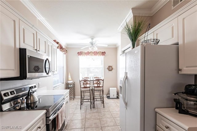 kitchen featuring white cabinetry, appliances with stainless steel finishes, crown molding, and light tile patterned floors