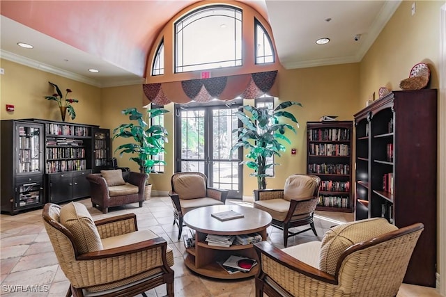 sitting room with a towering ceiling and ornamental molding