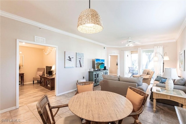 dining room featuring light tile patterned floors, baseboards, visible vents, ceiling fan, and crown molding