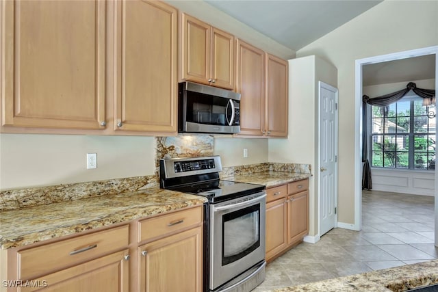 kitchen with appliances with stainless steel finishes, light brown cabinets, and light stone counters