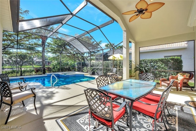 view of swimming pool with ceiling fan, a patio, and glass enclosure